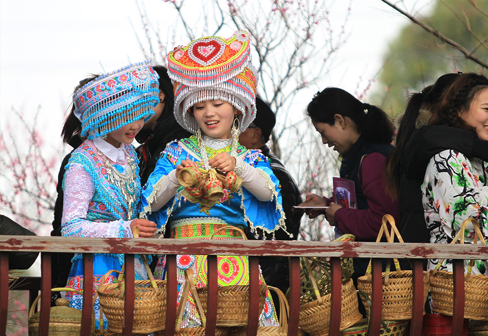 身着传统民族服装的苗族姑娘，在驻足挑选王店篮
