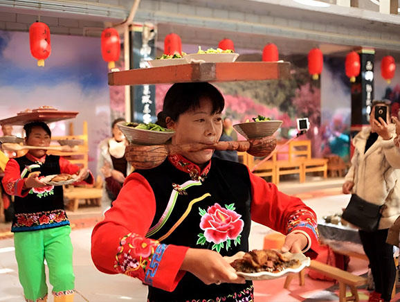 身着传统服饰的阿姨在上菜