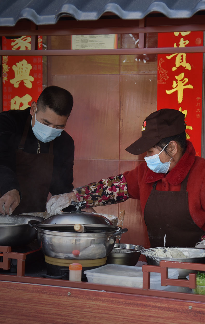 2021年3月24日，俞邦村沙县小吃技艺传承人在家门口的摊位上制作当地美食夏茂粽子。