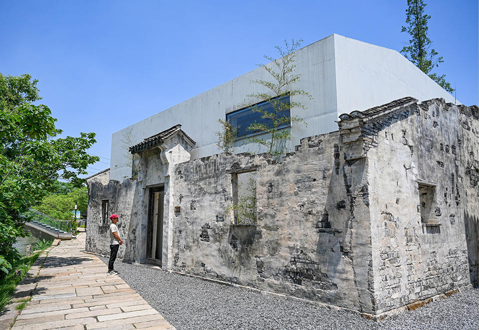 章堰文化馆以“章家宅”旧址为基底，原有的老墙被保留，白色新建筑从里面重新“长”了出来。