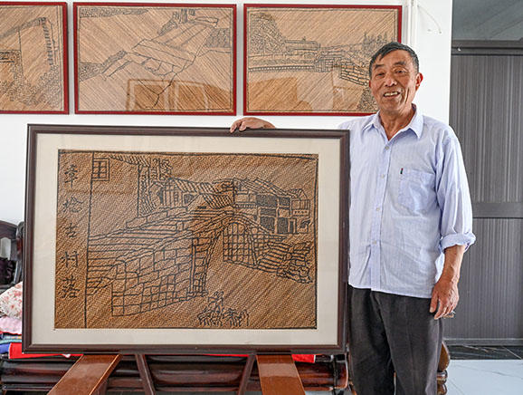 2023年5月，张元帅展示以章堰村村貌为题材的竹编画。